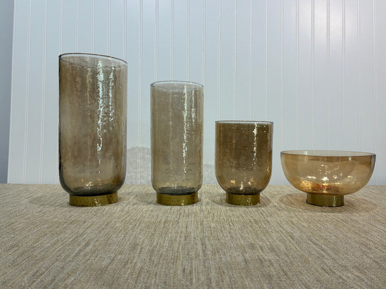 Collection of beige vases on wooden floor with a white background