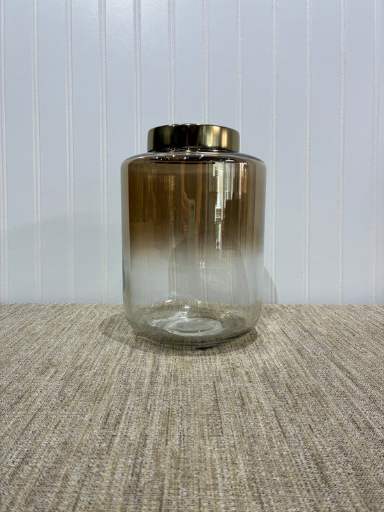 Beige Ombre glass vase with gold cap on a textured surface