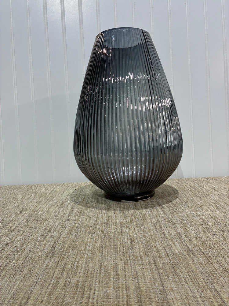 Black ribbed glass vase on a textured wall