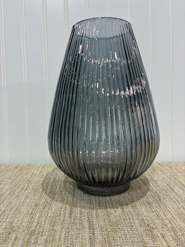 Decorative ribbed vase on a textured surface