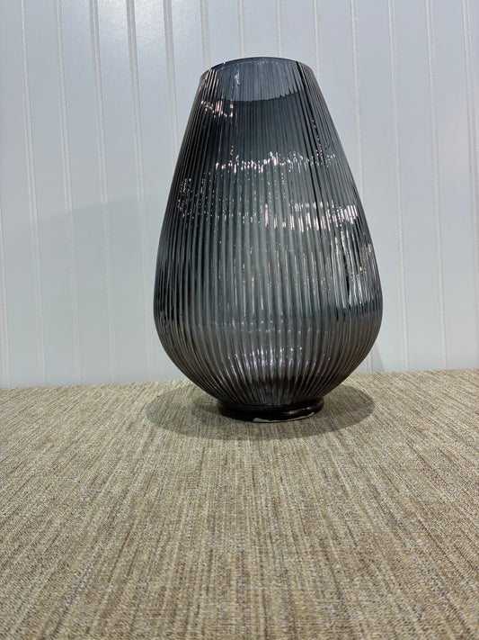 Black ribbed glass vase on a textured wall