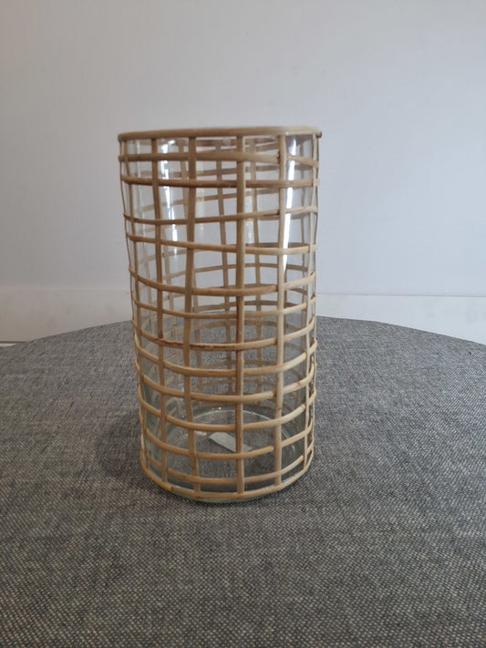 Wicker basket vase on a textured surface with a neutral background
